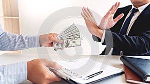 Businessman`s Hand Refusing To Take Bribe cash banknote from business partner, anti-corruption and venalityÂ concept